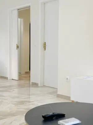a room with a table with a remote control on it at Palio Faliro Beach Luxury Apartments in Athens