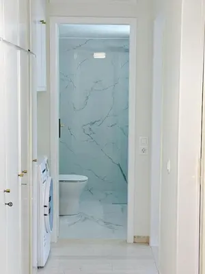 a bathroom with a toilet and a glass shower door at Palio Faliro Beach Luxury Apartments in Athens