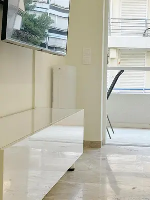a white room with a window and a table at Palio Faliro Beach Luxury Apartments in Athens