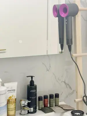 a hair dryer sitting on a counter next to a shelf at Palio Faliro Beach Luxury Apartments in Athens