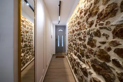 a hallway with a stone wall and a door at Panos City Apartment - Private parking for motorcycles in Athens