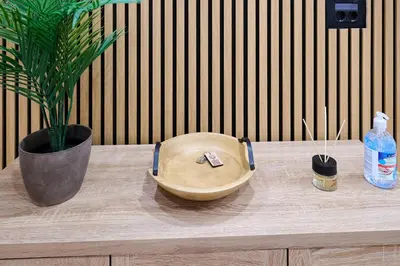 a wooden bowl sitting on a wooden table with a potted plant at Panos City Apartment - Private parking for motorcycles in Athens
