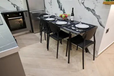 a black table with black chairs and a bottle of wine at Panos City Apartment - Private parking for motorcycles in Athens