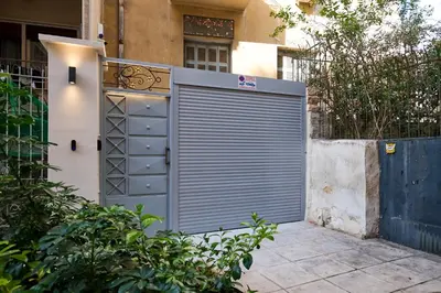 a metal garage door in front of a house at Panos City Apartment - Private parking for motorcycles in Athens