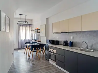 a kitchen with a sink and a table with chairs at Central Hideaway Near Ermou Street Perfect For Groups And Families in Athens