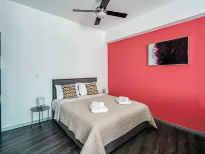 a bedroom with a bed with a red wall at Central Hideaway Near Ermou Street Perfect For Groups And Families in Athens