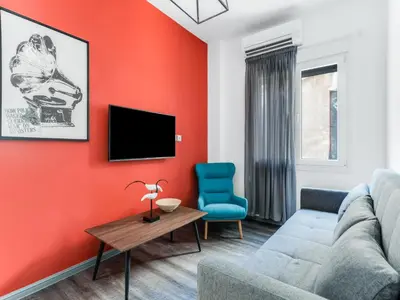 a living room with a couch and a tv at Central Hideaway Near Ermou Street Perfect For Groups And Families in Athens