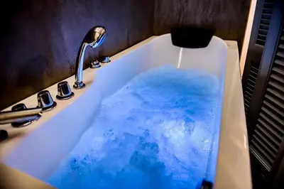 a bath tub filled with blue water in a sink at Athenian Hideaway - Spa Tub and Walk to Metro in Athens