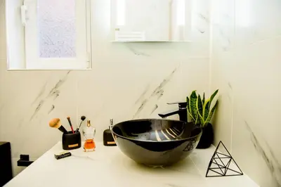 a bathroom with a bowl sink on a counter at Athenian Hideaway - Spa Tub and Walk to Metro in Athens