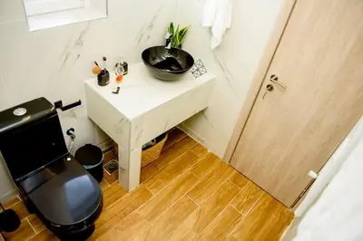 a small bathroom with a sink and a toilet at Athenian Hideaway - Spa Tub and Walk to Metro in Athens
