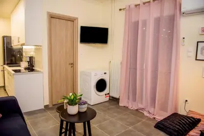 a living room with a washing machine in a room at Athenian Hideaway - Spa Tub and Walk to Metro in Athens
