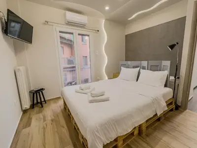 a bedroom with a large white bed with towels on it at Athenian Hideaway - Spa Tub and Walk to Metro in Athens