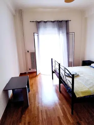 a bedroom with a bed and a table and a window at Berry room 4 in Athens