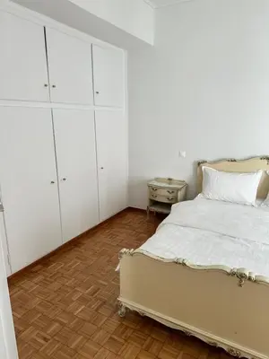 a white bedroom with a bed and a dresser at Graffiti One Studio in Athens