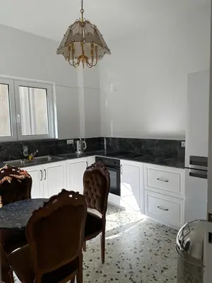 a kitchen with a table and chairs and a chandelier at Graffiti One Studio in Athens