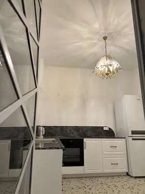 a kitchen with white appliances and a chandelier at Graffiti One Studio in Athens