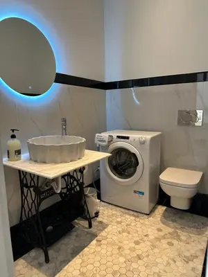 a bathroom with a washing machine and a sink at Graffiti One Studio in Athens