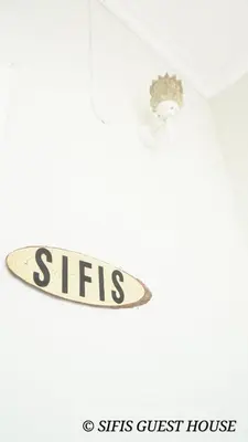 a sign that says sirs guest house on a ceiling at Sifis home in Athens