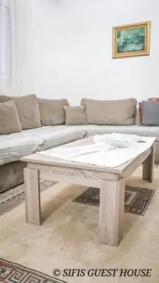 a wooden coffee table in a living room with a couch at Sifis home in Athens