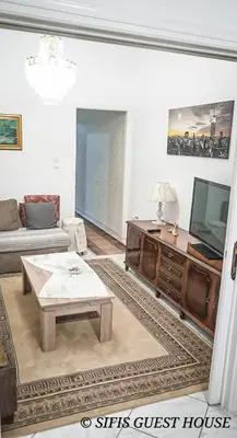 a living room with a couch and a tv at Sifis home in Athens