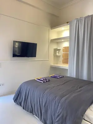 a bedroom with a bed with two towels on it at White Gem of Piraeus in Piraeus