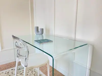a glass desk with a chair and a vase at White Gem of Piraeus in Piraeus