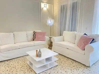 a living room with two white couches and a table at White Gem of Piraeus in Piraeus