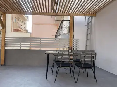 a table and chairs in a room with a staircase at White Gem of Piraeus in Piraeus