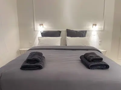 a bed with two towels on top of it at White Gem of Piraeus in Piraeus