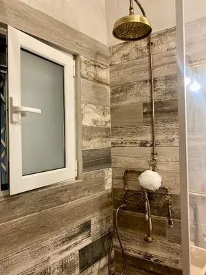 a bathroom with a wooden wall with a shower at Athens Acropolis Living in Athens