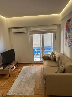 a living room with a couch and a television at AtticNest in Athens