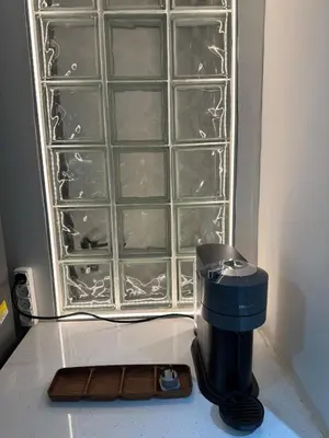 a coffee maker sitting on a counter next to glass panels at AtticNest in Athens