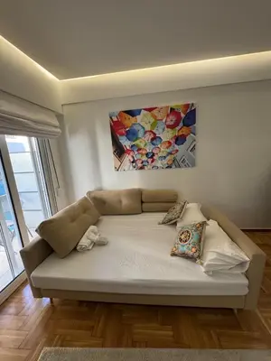 a bed in a room with a painting on the wall at AtticNest in Athens