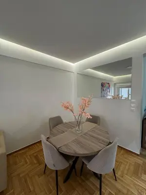 a dining room table with chairs and a vase with flowers at AtticNest in Athens