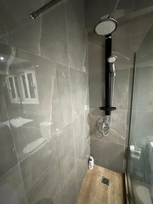 a bathroom with a shower with a glass door at AtticNest in Athens