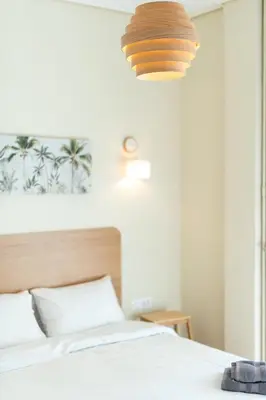 a bedroom with a white bed with a wooden headboard at Frederic - 2BR in the Historic Center in Athens