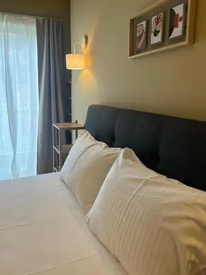 a bed with white sheets and a blue headboard at Frederic - 2BR in the Historic Center in Athens