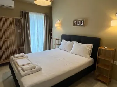 a bedroom with a bed with white sheets and a window at Frederic - 2BR in the Historic Center in Athens