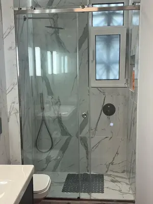 a shower with a glass door in a bathroom at Frederic - 2BR in the Historic Center in Athens