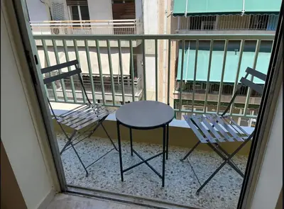 two chairs and a table on a balcony at Frederic - 2BR in the Historic Center in Athens