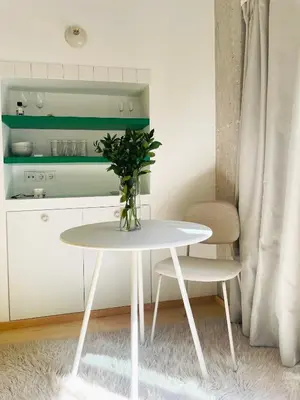 a white table with a vase on it in a room at Apartment in Exarchia in Athens