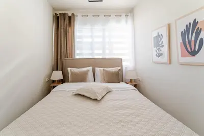 a bedroom with a large bed with white sheets at Brand New Modern Stylish 6BDR 3BATH APT-Athens in Athens