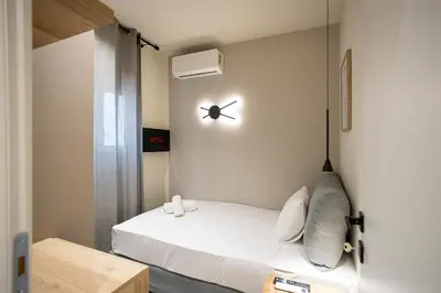 a room with a bed with a clock on the wall at Cozy Luxury Apartment in Athens in Athens