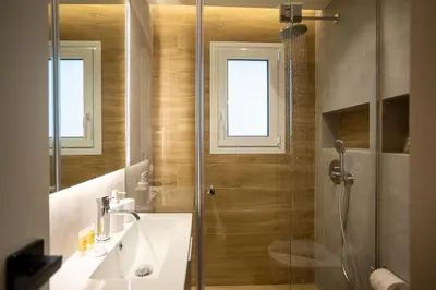 a bathroom with a shower and a sink and a mirror at Cozy Luxury Apartment in Athens in Athens