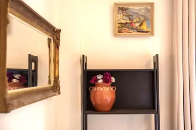 a vase sitting on a shelf next to a mirror at Spacious and bright apt in Eksarchia in Athens