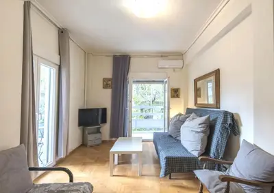 a living room with a couch and a tv at Spacious and bright apt in Eksarchia in Athens
