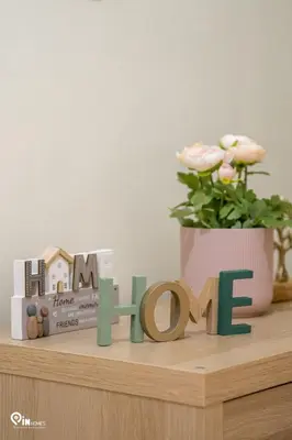 a wooden sign that says love on a shelf with a plant at Gardenia - Cozy House Near Piraeus in Piraeus