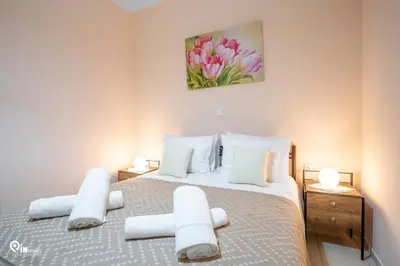 a bedroom with a large bed with white pillows at Gardenia - Cozy House Near Piraeus in Piraeus