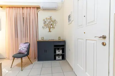 a room with a chair and a door and a table at Orchid - Stylish Home Near Piraeus in Piraeus