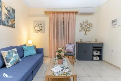 a living room with a blue couch and a table at Orchid - Stylish Home Near Piraeus in Piraeus